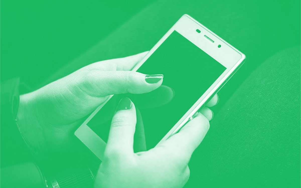 Photo of person using smartphone with a green overlay.